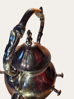 Vintage Ornate Silver-Plated Teapot With Intricate Handle Design And Hinged Lid